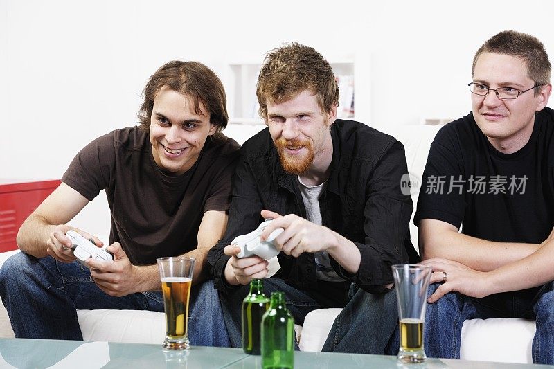 年轻人玩互动/电子游戏和喝啤酒